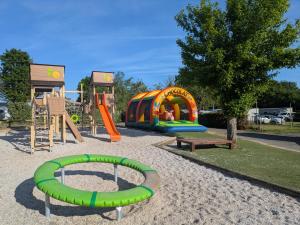 a playground with a slide and a play structure at Camping Le Ragis in Challans