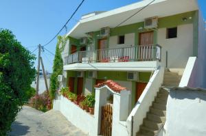 a white building with stairs and a balcony at Anais Studios in Patitiri +12 photos