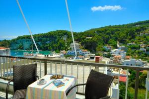 a table on a balcony with a view of a harbor at Anais Studios in Patitiri