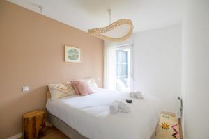 a bedroom with a bed with white sheets and a window at Bright House between Ocean and Golf in Moliets-et-Maa