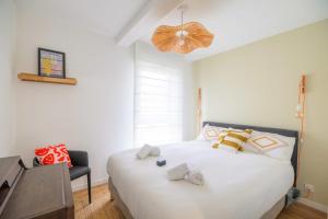 a bedroom with a large white bed and a desk at Bright House between Ocean and Golf in Moliets-et-Maa