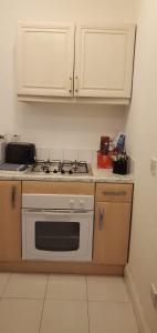 a kitchen with a stove and white cabinets at Comfortable 2-Bed Flat with Free Parking in Paisley +4 photos