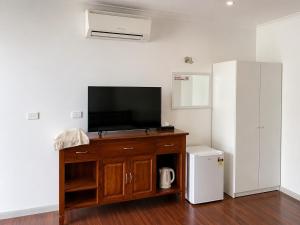 a living room with a tv and a small refrigerator at Beaconsfield Lodge Motel in Beaconsfield