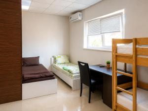 a room with a desk and a bed and a bunk bed at PANORAMA HOTEL in Tyachiv