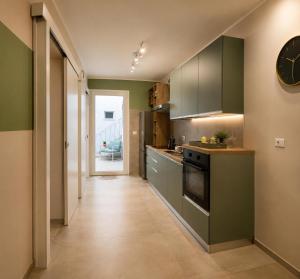 a kitchen with green cabinets and a clock on the wall at L altra Volta in San Pietro Vernotico