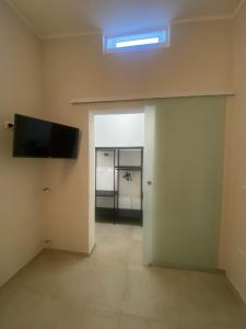 an empty room with a flat screen tv on the wall at L altra Volta in San Pietro Vernotico +12 photos