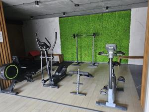 a gym with several tread machines and a green wall at Apartament Pruszcz Gdański 1 in Pruszcz Gdański +4 photos