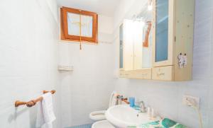 a white bathroom with a sink and a toilet at Appartamento Vista Nel Mare Blu in Rio nellʼElba +10 photos