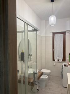 a bathroom with a toilet and a glass shower at Respiro Di Mare in Torre del Greco