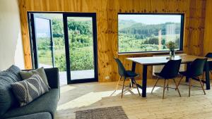 a living room with a table and chairs and a couch at Nykmark Eco Residence in Unnstad