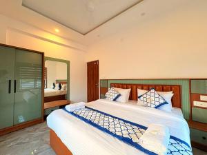 a bedroom with a large bed and a mirror at Pullat Suites in Kalpetta