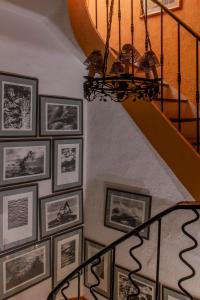 a staircase with pictures on the wall and a chandelier at Mas de la Chapelle in Arles