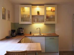 a kitchen with white cabinets and a sink at Eifel Moments in Kall