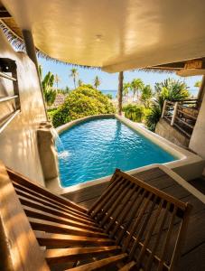 a swimming pool with a bench in front of it at The Rock Samui Beachfront Resort - Sha Plus Hotel in Lamai