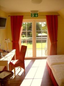 a bedroom with a desk and a bed and a desk and a window at Hotel Landhaus Garni in Fockbek