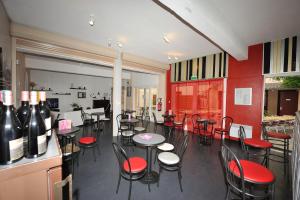 a restaurant with tables and chairs and red walls at Hôtel des Bateliers in La Malène