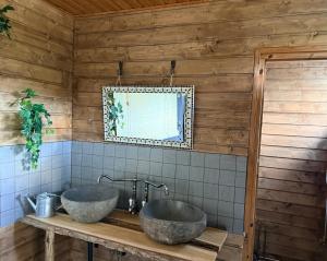 a bathroom with two sinks on a wooden wall at Kangasjoki Riverside Camp in Suomussalmi +29 photos