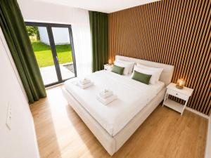 a bedroom with a large white bed and a large window at Apartmán Javorná Living in Čachrov