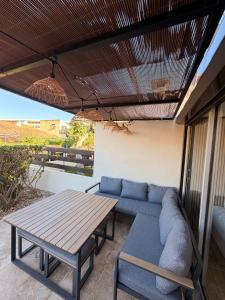 a blue couch and a table on a patio at Sexty-nine, villa 69 héliovillage in Cap d'Agde