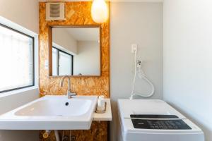 a bathroom with a sink and a mirror at WaKaRaN9111 和華蘭文化を体感! 長崎情緒あふれる一軒家 in Nagasaki
