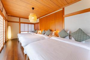 a row of four beds in a room at WaKaRaN9111 和華蘭文化を体感! 長崎情緒あふれる一軒家 in Nagasaki +69 photos