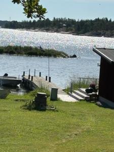 a dock on a body of water with a house at Bryggstuga med privat bastu in Norrtälje