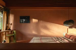 a bedroom with a bed and a table and a window at Moon Gang Ubud in Ubud