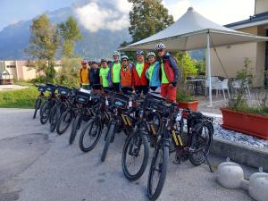 a group of people standing next to a row of bikes at Hotel Dante in Ponte nellʼAlpi