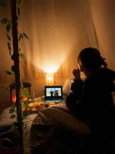 a woman sitting on a bed with a laptop computer at Debed Glamping in Debed
