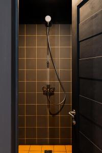 a shower in a bathroom with a tile wall at Globe Runner Rooms & Dorms in Kyiv +135 photos