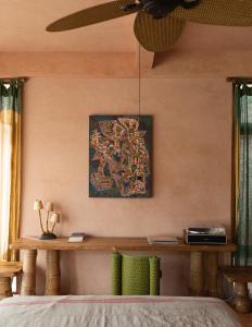 a bedroom with a table and a painting on the wall at Moon Gang Ubud in Ubud +40 photos