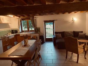 a kitchen and living room with a table and a couch at Gîte des Charbonneaux in Avrée