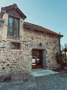 a stone house with a door with a car parked outside at Gîte des Charbonneaux in Avrée +3 photos