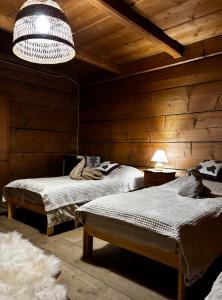 a bedroom with two beds and a chandelier at Prociówka in Ciche