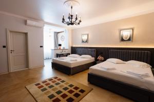 a bedroom with two beds and a chandelier at Vila Sibiu in Sibiu