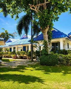 a house with a blue roof and a palm tree at Sunset Beach Villas in Haad Rin