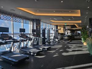 a gym with cardio equipment in a building with windows at Layers Hotel Busan Hadan in Busan
