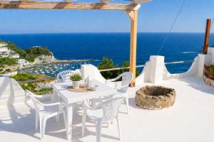 a white table and chairs on a balcony with the ocean at Maridea - Vela in Ponza
