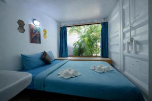 a bedroom with a blue bed with two towels on it at White Rabbit Hostel in Siem Reap