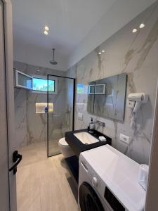 a bathroom with a sink and a toilet and a mirror at Rajan Villas in Vlorë