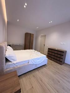 a bedroom with a large bed and a wooden floor at Rajan Villas in Vlorë