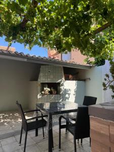 a patio with a table and chairs and a fireplace at Monolocale in un piccolo paradiso in Tramatza