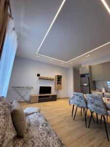 a living room with a couch and a table with chairs at Rajan Villas in Vlorë