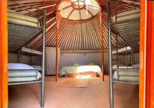 a bedroom with two bunk beds and a ceiling at Yourtes Corse Le pré aux biches in Zonza