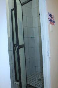 a shower with a glass door in a bathroom at Prax Guest House Benoni in Benoni