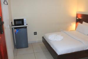 a hotel room with a bed and a tv at Prax Guest House Benoni in Benoni