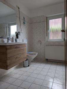 a bathroom with a sink and a toilet and a window at Fewo Neuruppin Einliegerwohnung in Neuruppin