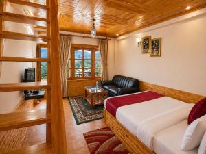 a bedroom with a bed and a couch in a room at Hotel Hollywood Manali - Scenic River & Mountain View With Premium Rooms Near Mall Road in Manāli