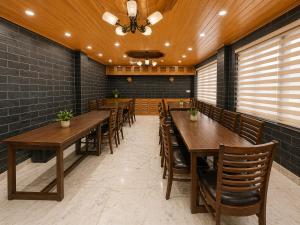 a dining room with wooden tables and chairs at Hotel Hollywood Manali - Scenic River & Mountain View With Premium Rooms Near Mall Road in Manāli