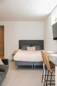 a bedroom with a bed and a table and a couch at The Dune gate in Zandvoort